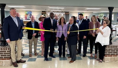 Ribbon-cutting ceremony with staff and visitors in a common area