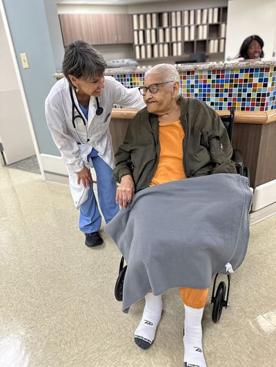 Healthcare staff assisting a resident in a common area