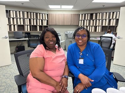 Two staff members smiling in an office setting