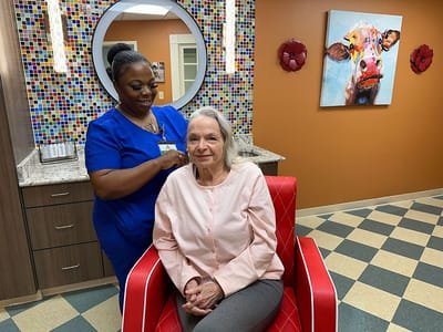 Resident receiving hair care in a colorful salon area