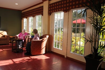 Residents chatting in a bright common area with large windows