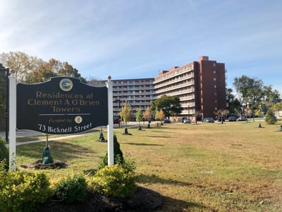 Sign for the Clement A O'Brien Towers with the building in the background