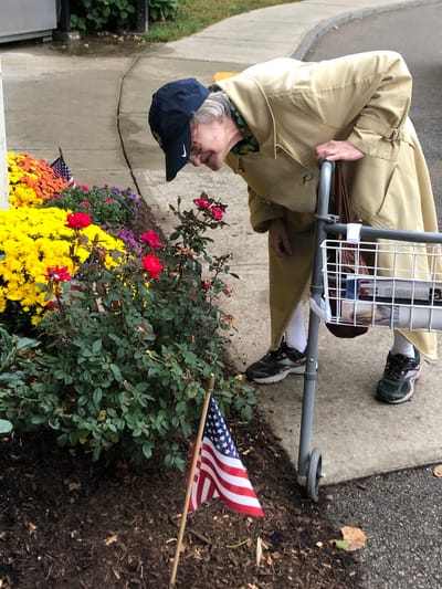 Resident admiring flowers in a garden area