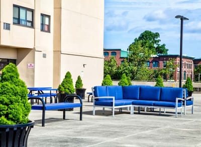 Outdoor seating area with blue furniture and greenery
