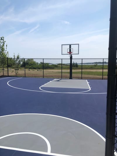 Outdoor basketball court with fenced area