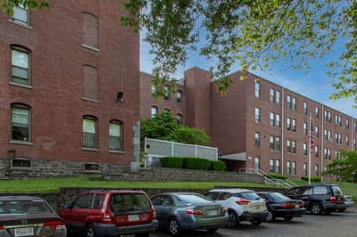 Exterior view of Mazur Park Apartments with cars parked