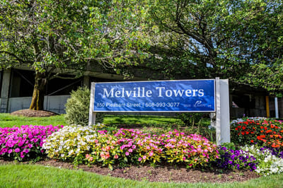 Entrance sign with flowers at Melville Towers