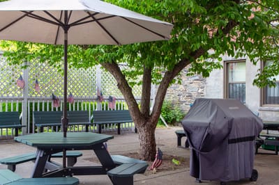 Outdoor patio area with picnic tables and grill