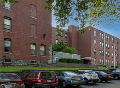 Exterior view of Mazur Park Apartments with parked cars