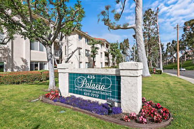 Exterior view of Palacio Senior Apartments sign and greenery