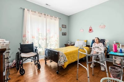 Resident in a private room with wheelchairs visible