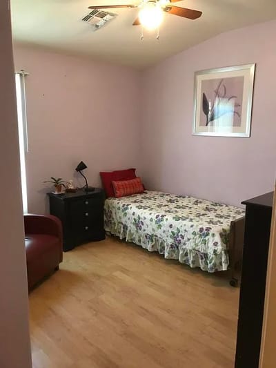 A cozy resident room with a bed and seating area
