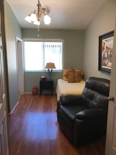A cozy resident room with light decor and furniture