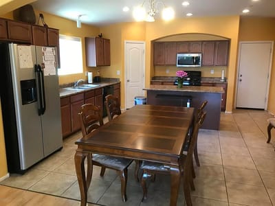 Well-lit kitchen area with wooden dining table