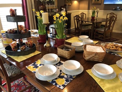 Dining table set with food and flowers in a common area