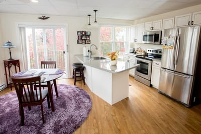 Bright kitchen area with dining table and modern appliances
