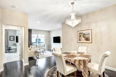 Bright common area with dining table and chandelier.