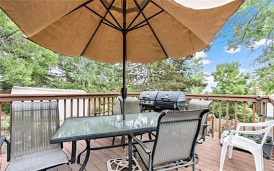 Outdoor seating area with barbecue grill under an umbrella