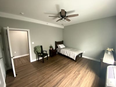 A private resident room with a bed and chair