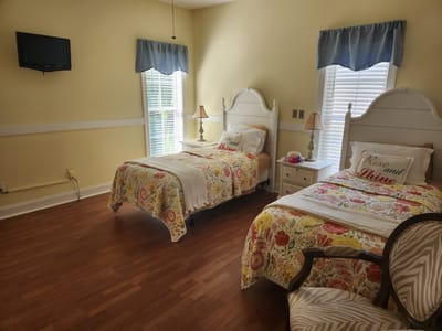 Bright resident room with two twin beds and decor