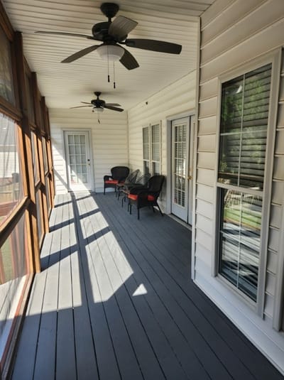 A sunny screened-in porch with seating