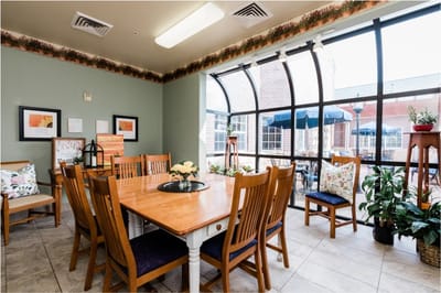 Interior dining area with large windows and plants