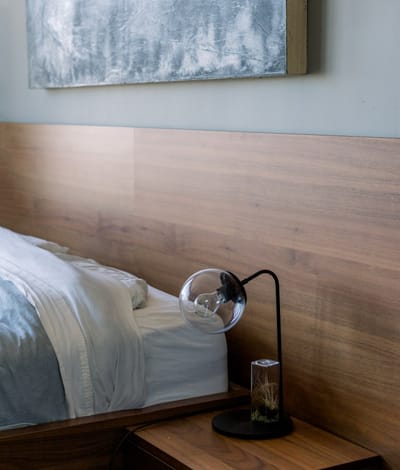 Cozy bedroom with modern decor and bedside lamp.