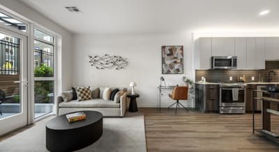Modern living room with kitchen area.