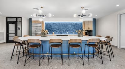 Modern kitchen area with seating and blue accents