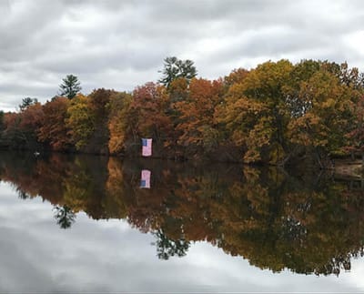 Autumn reflection on a lake with colorful trees.