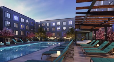 Outdoor pool area with lounge chairs and trees.