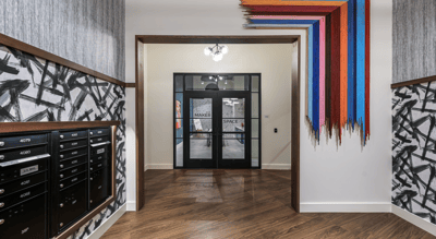 Entrance area with mailboxes and artistic wall decor.
