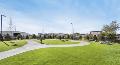Green outdoor space with seating and walking paths.