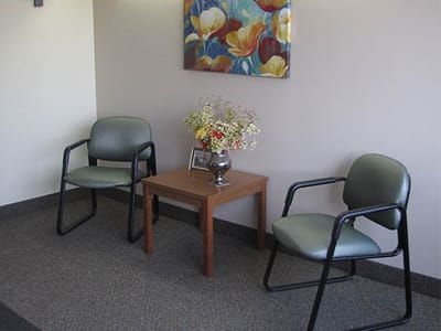 Seating area with floral artwork and table.