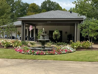 Exterior view of the facility with landscaping and fountain.
