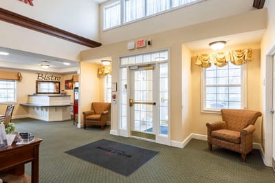 Interior lobby area with chairs and a welcome mat.
