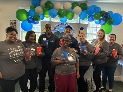 Staff members celebrating with drinks and smiles.