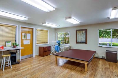 A bright activity room with windows and hardwood floors