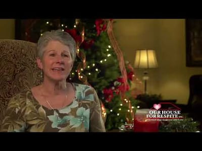 Senior woman speaking in a festive common area.