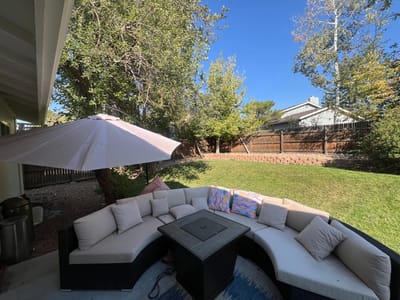 Seating area with a patio umbrella in a garden.