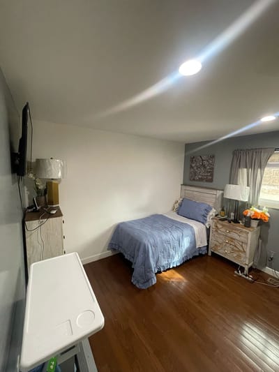 Cozy resident bedroom with wooden flooring and decor