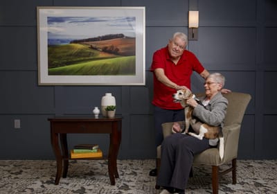 Residents enjoying time together in a common area with a dog