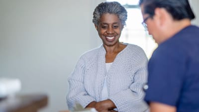 A smiling resident engaging with staff attentively