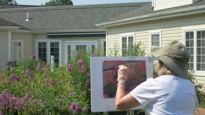 Resident painting in the garden with flowers