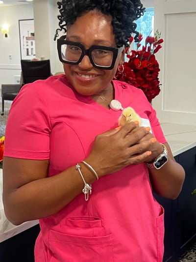 A staff member holding a chick in a bright common area