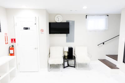 Bright interior seating area with white chairs and television