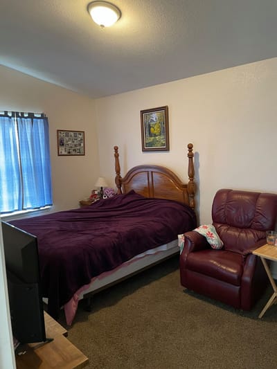 Cozy private resident room with a bed and armchair