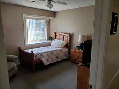 Cozy private resident room with a bed and chair