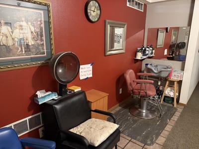 Hair salon area with red walls and styling equipment