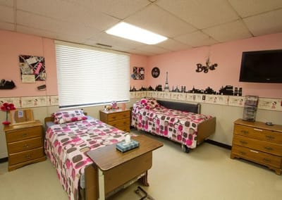 Private resident room with two beds and colorful decor